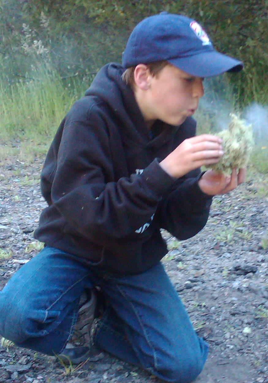 kid blowing coal into flames